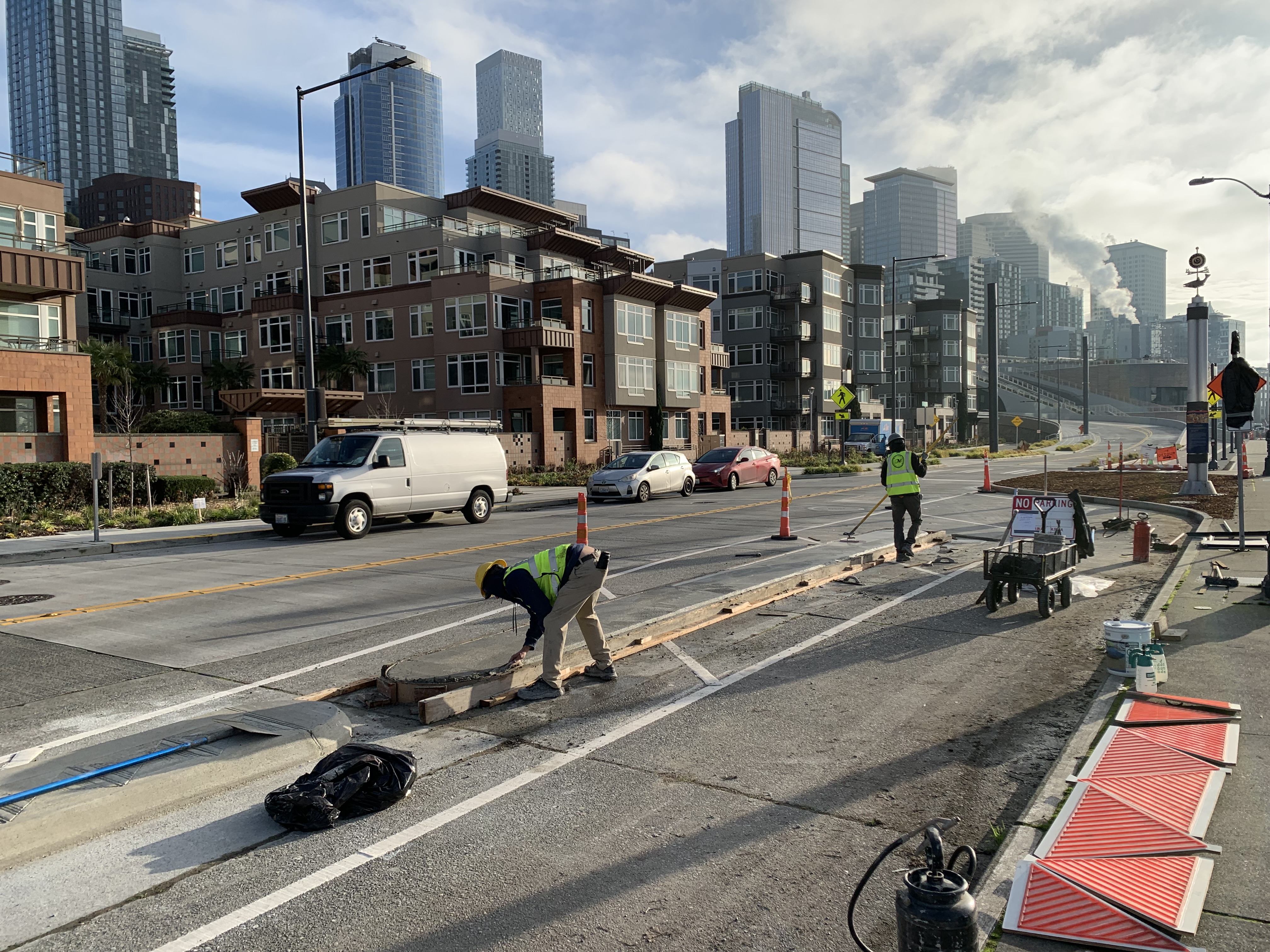 Workers lay new concrete curbs along Alaskan Way